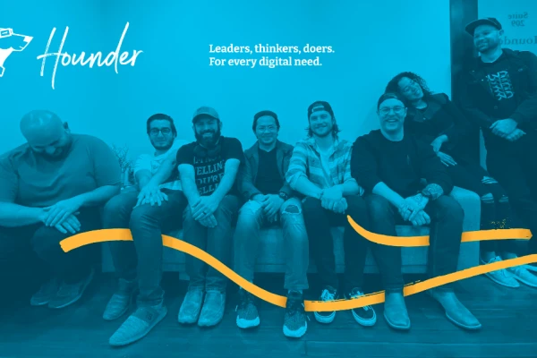 Group photo of Hounder team members sitting and smiling with the tagline “Leaders, thinkers, doers. For every digital need.”