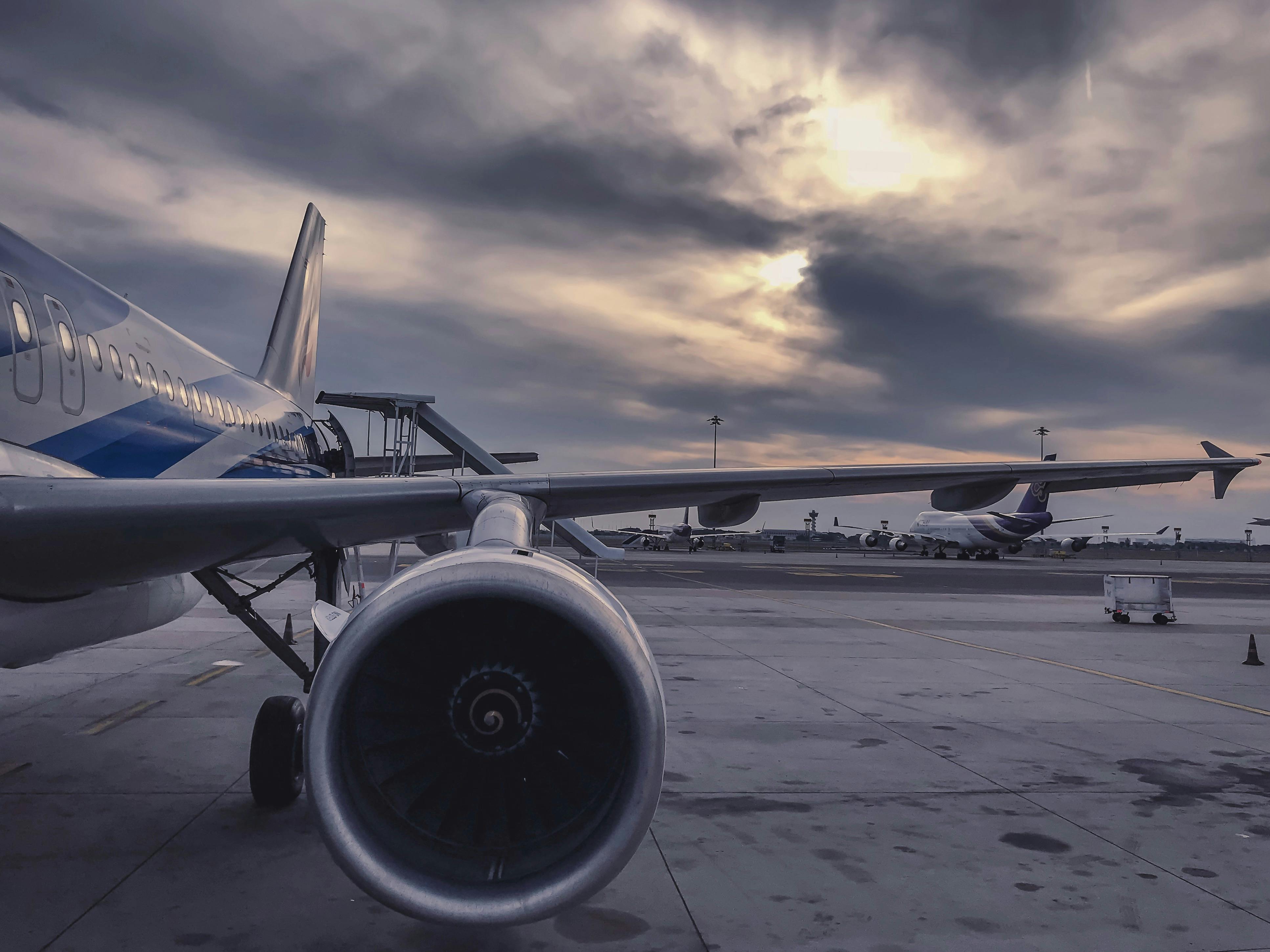 airplane engine parked on the tarmac with a cloudy sky in the background