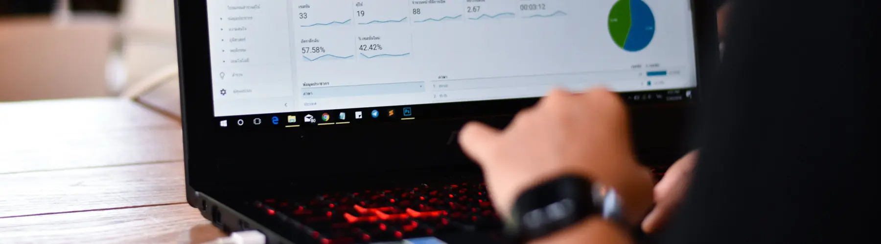 Person analyzing data on a laptop screen displaying graphs and charts.