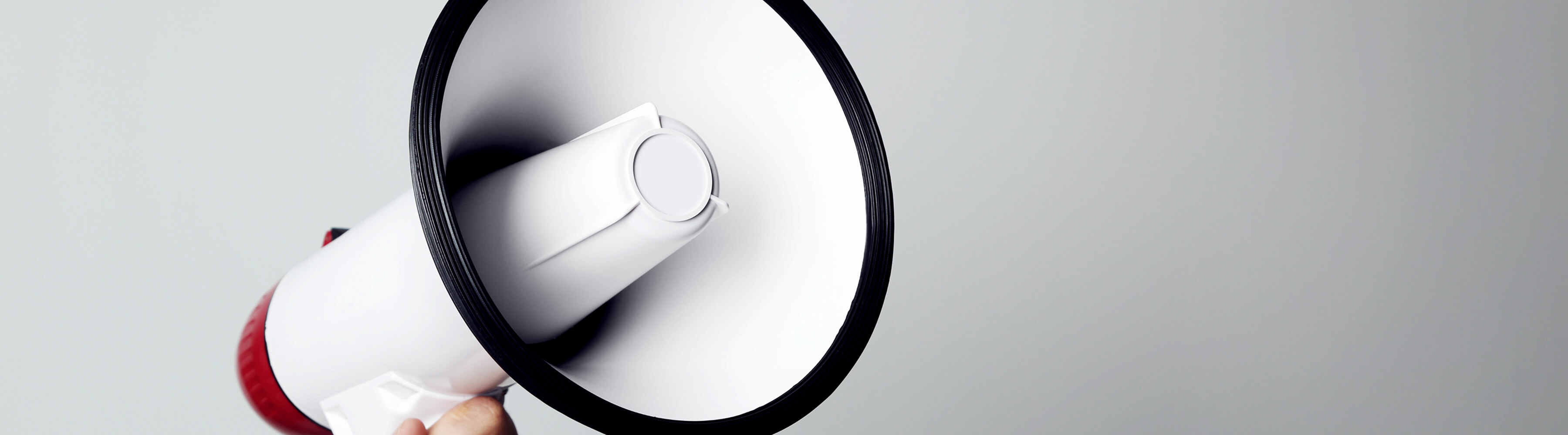 Megaphone held against a gray background.