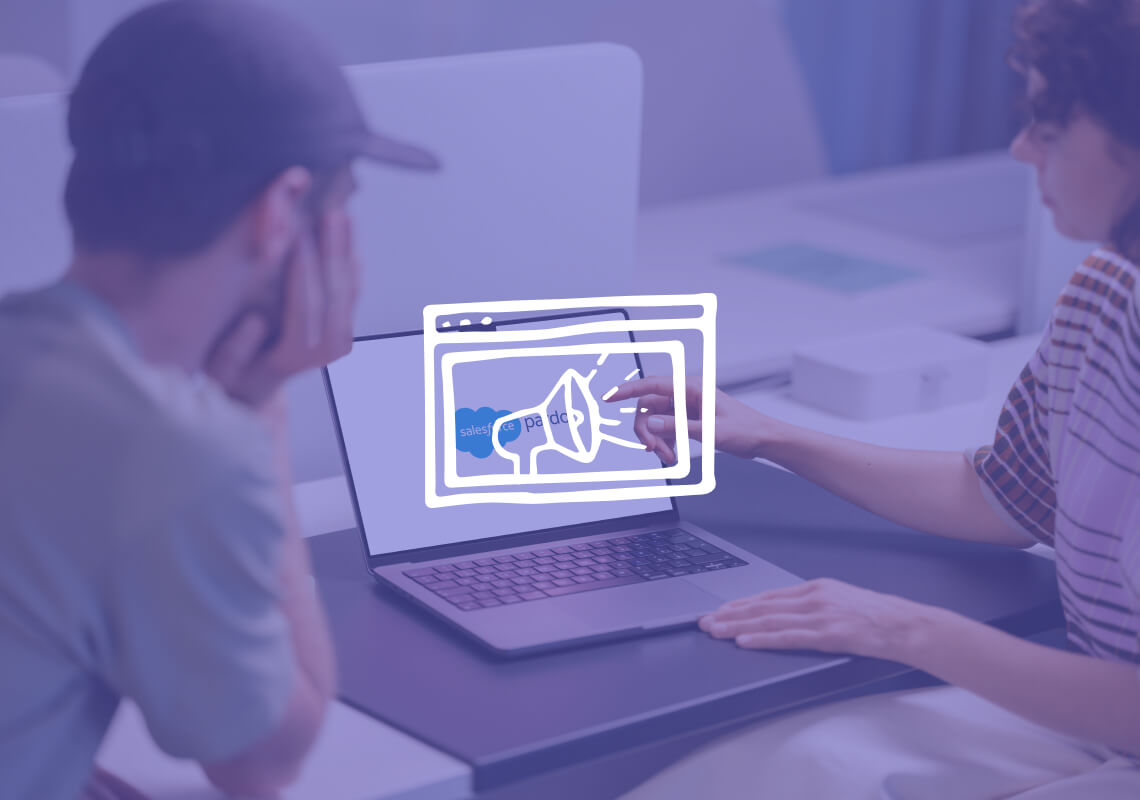 Two people discussing Salesforce Pardot on a laptop screen.
