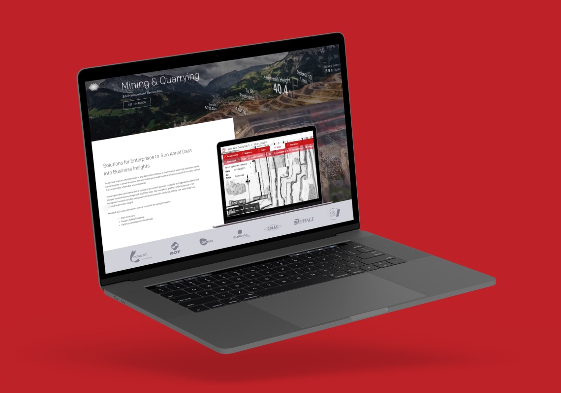 Laptop displaying a mining and quarrying data visualization on a red background.