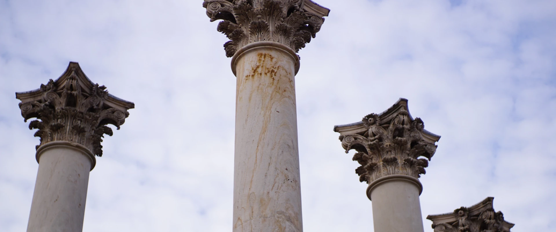 Corinthian columns against a cloudy sky.