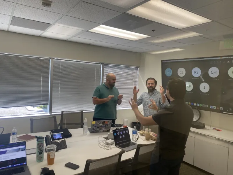 three employees of hounder discussing a strategy in a conference room during an onsite visit