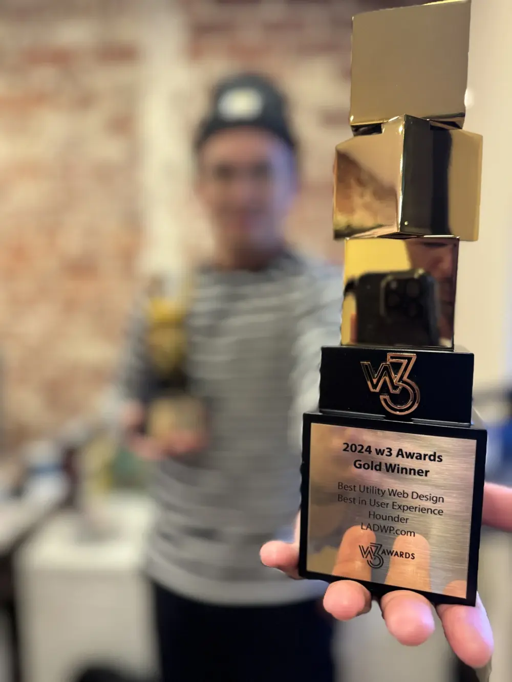 Hounder employee showcasing an award for best web design.