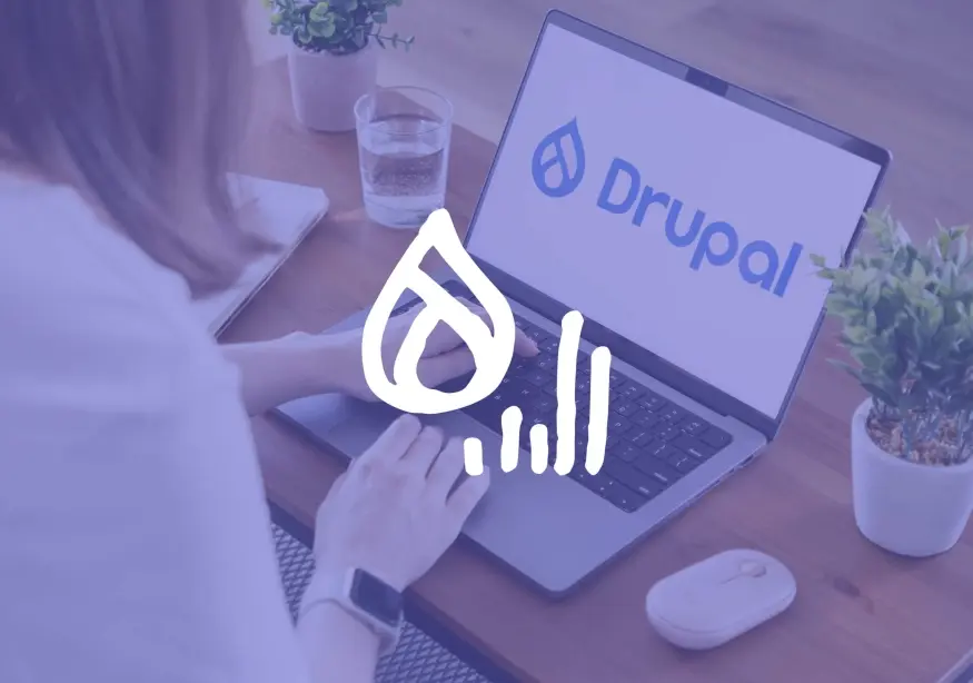 A woman types on a laptop displaying the Drupal logo.
