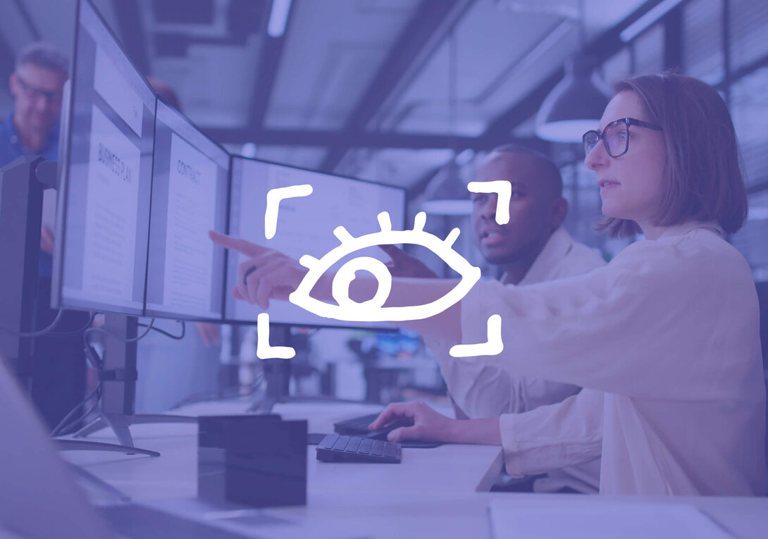 Woman pointing at computer screen in a modern office.