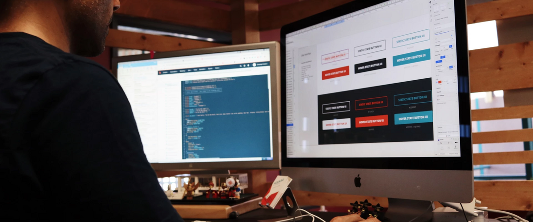 Designer working on UI elements and code on dual monitors in an office.