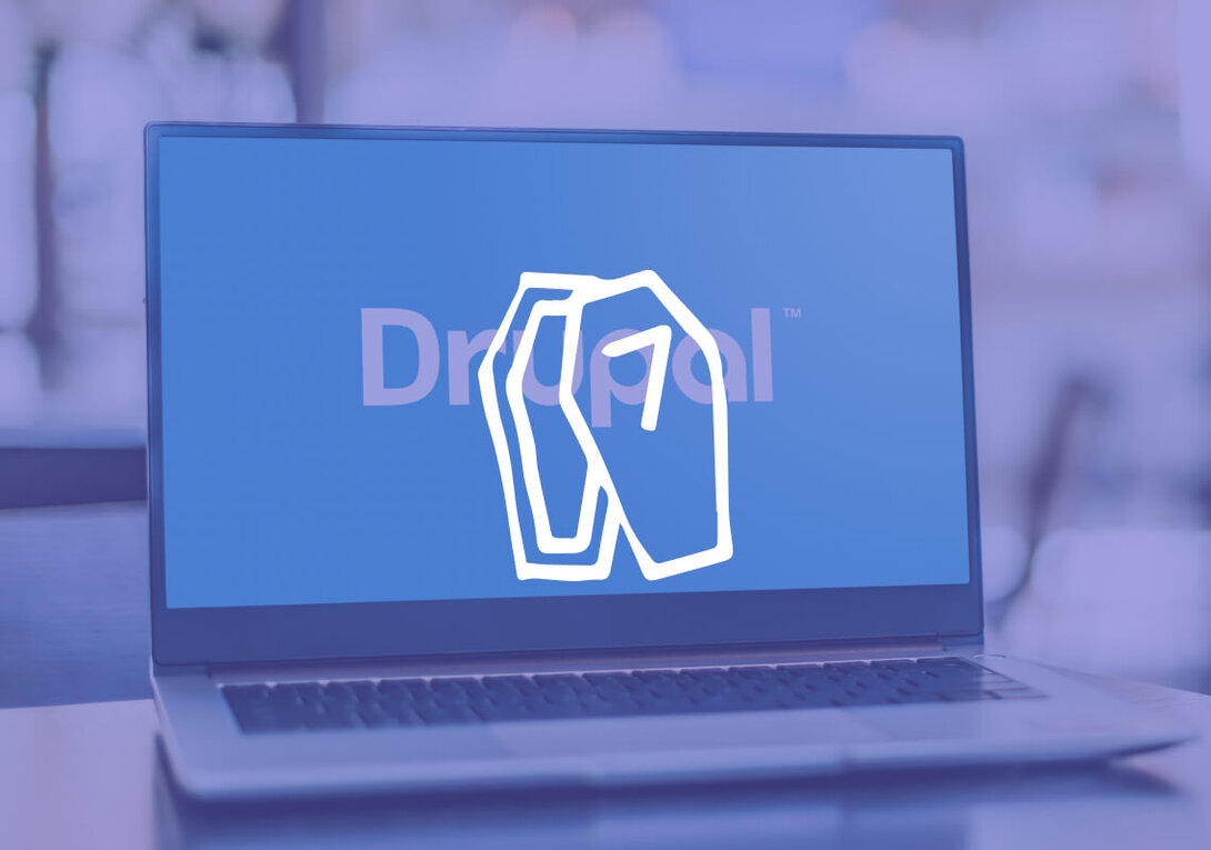 Laptop displaying Drupal 7 logo on a blue screen.