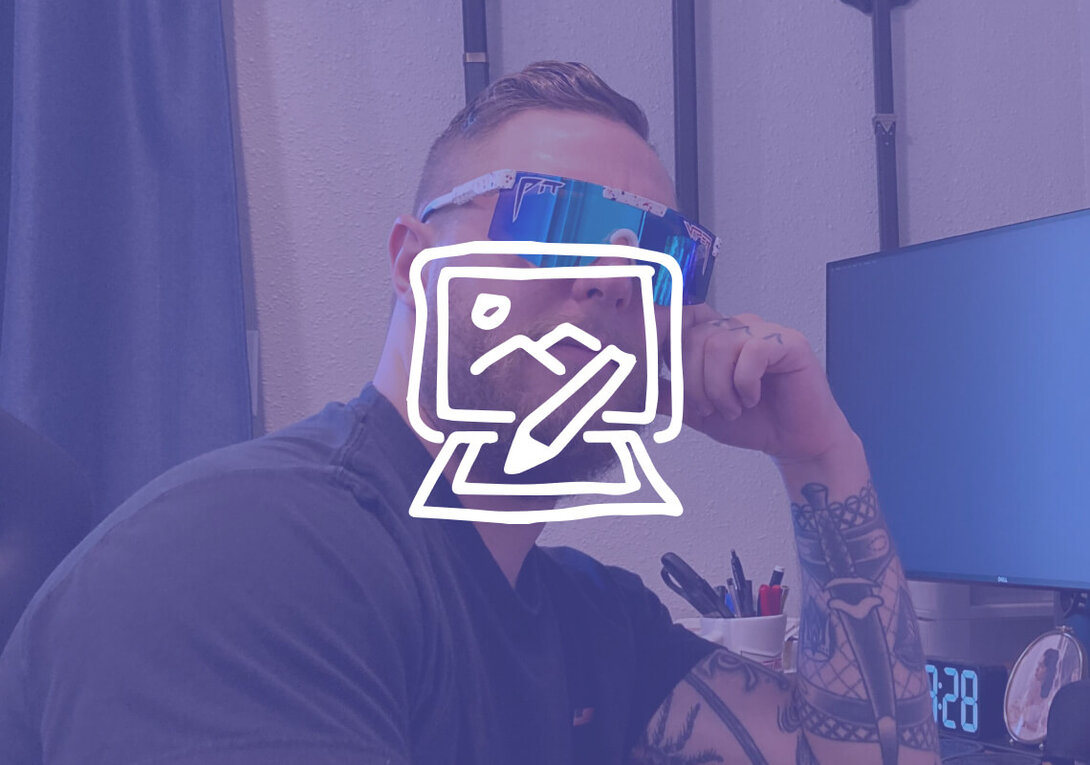 Person with tattooed arm wearing mirrored sunglasses in an office.