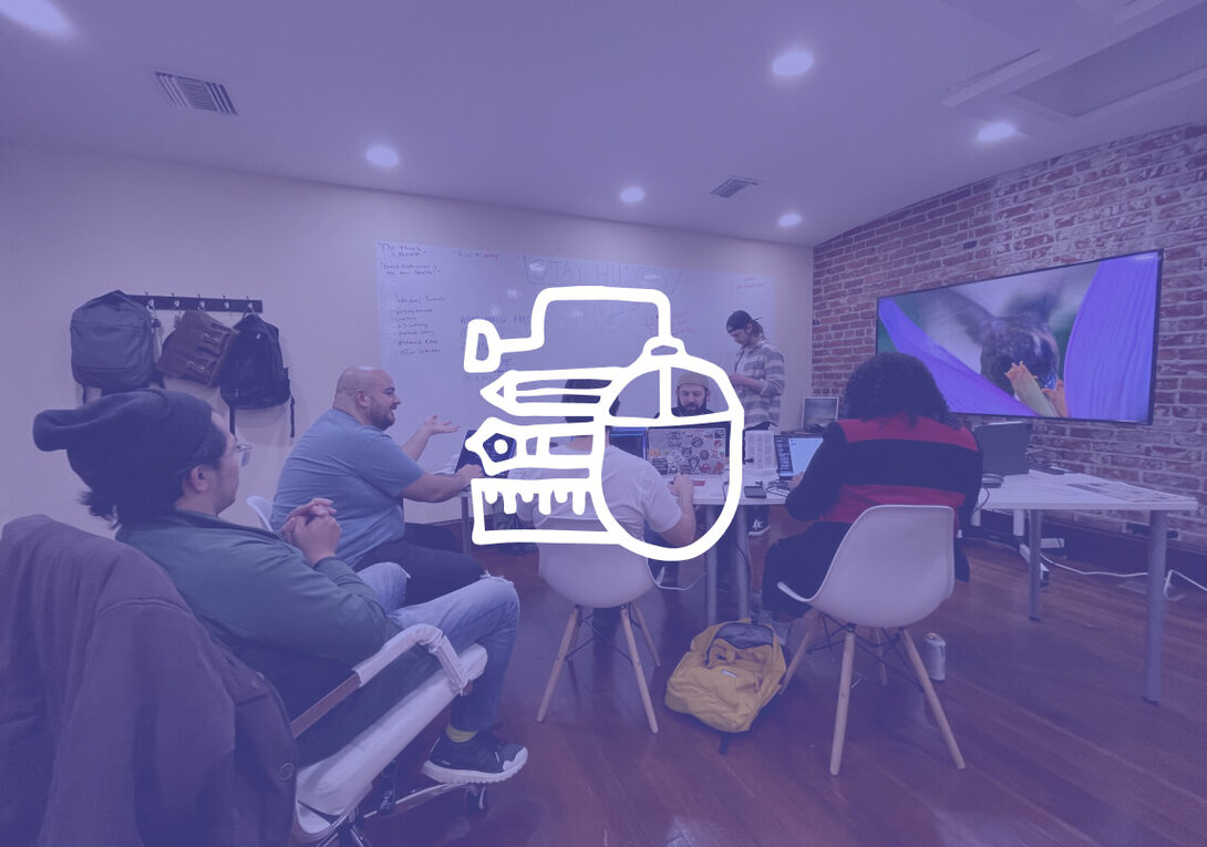 Group of people in a meeting room discussing with laptops and whiteboard.