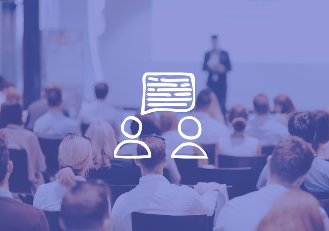 Audience attending a presentation with a speech bubble overlay.