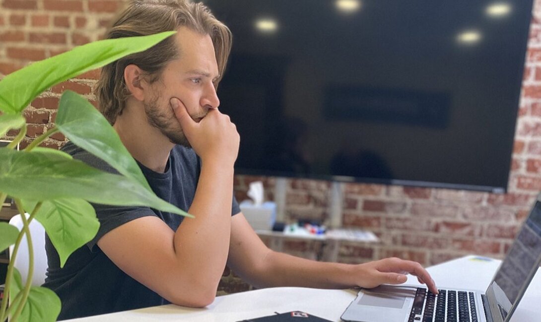 Man focused on laptop work in a modern office setting