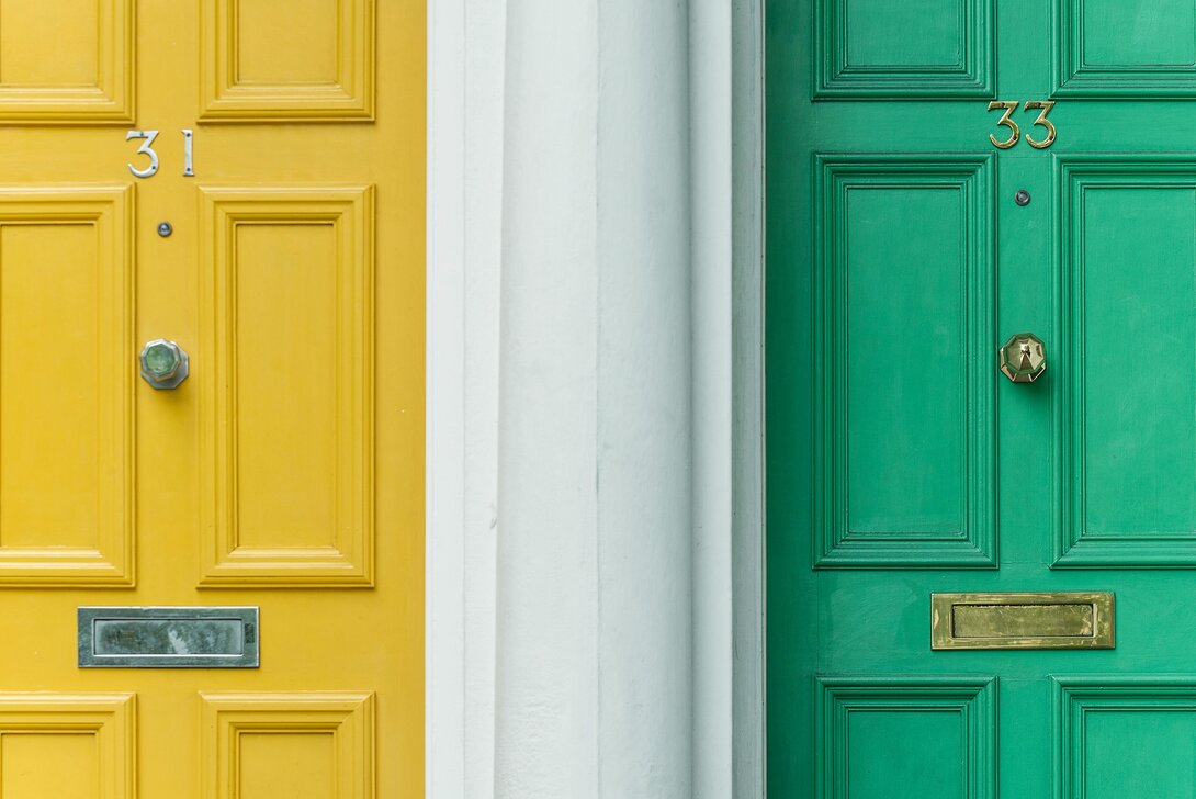 Brightly painted yellow and green doors with house numbers 31 and 33.