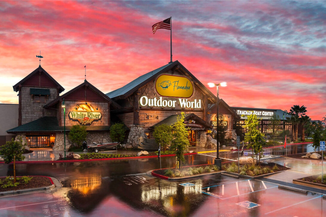 Outdoor World store exterior with a vibrant sunset sky.